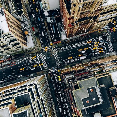 Aerial view of New York downtown building roofs. Bird's eye view from helicopter of cityscape metropolis infrastructure, traffic cars, yellow cabs moving on city streets and crossing district avenues