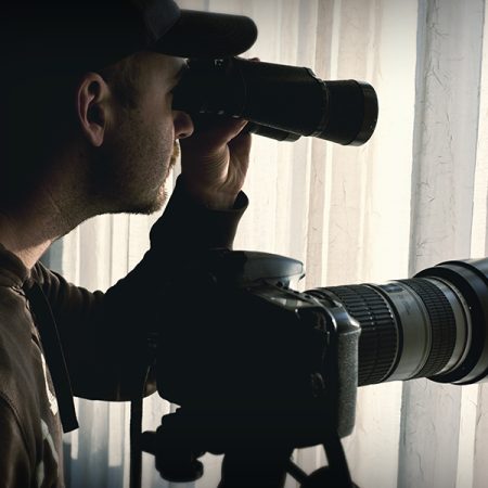 man with binoculars and camera control someone